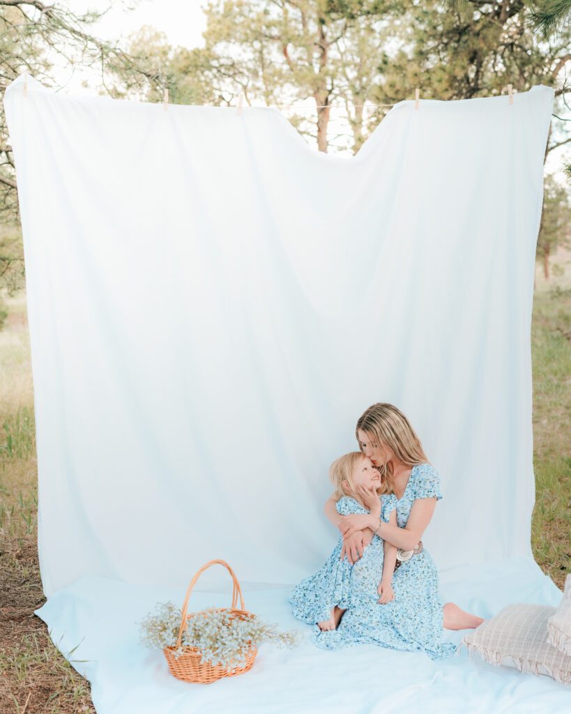 Motherhood mini soft spring mother kissing child in Colorado Springs styled setup 